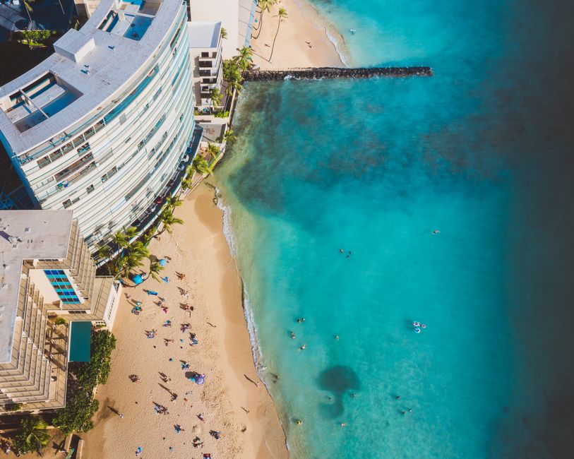Stunning aerial view of a beach resort with clear turquoise waters, attracting tourists for a perfect holiday.