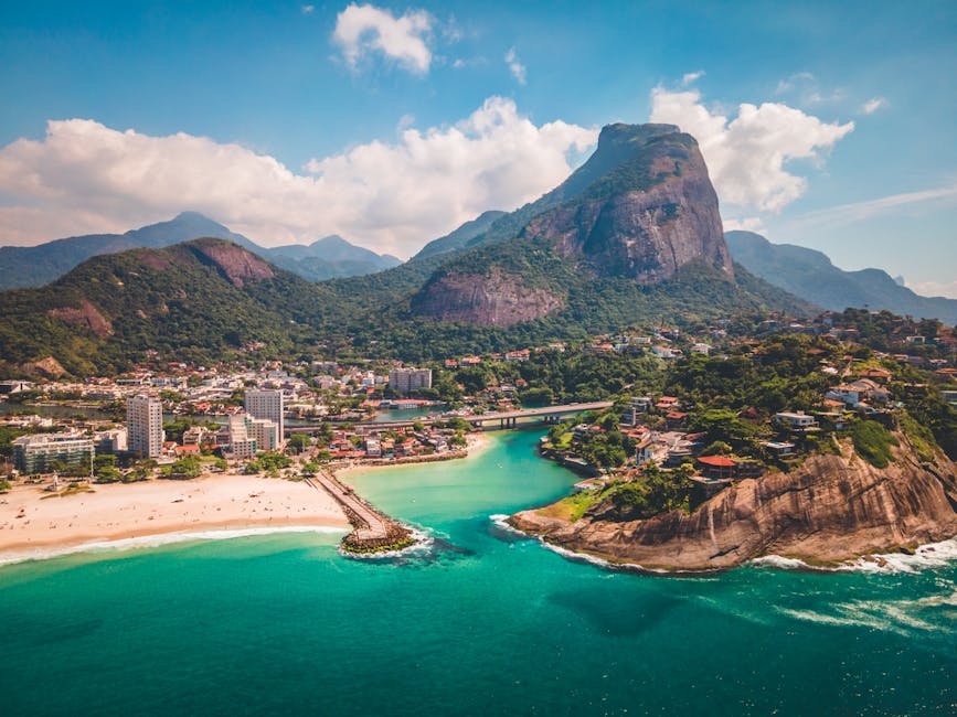 Stunning aerial view of a beach in Rio de Janeiro, showcasing blue waters and lush greenery.