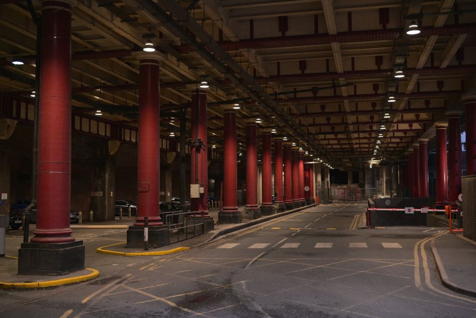 Dimly lit underground passage with striking red columns and intricate ceiling design.