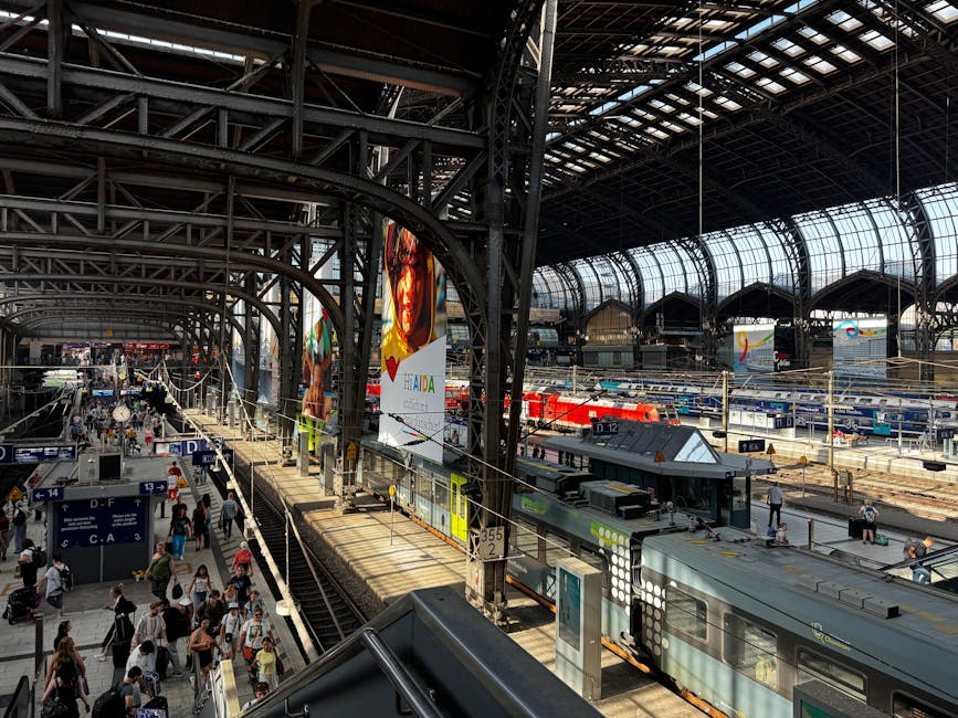A bustling view of Hamburg's central train station with passengers and trains under the iconic glass roof.