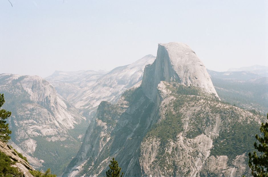Breathtaking view of Half Dome in Yosemite National Park, showcasing majestic rocky formations and lush greenery.