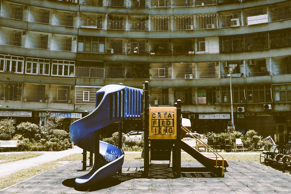 A colorful playground set against a vintage apartment in Taipei, showcasing urban exploration.