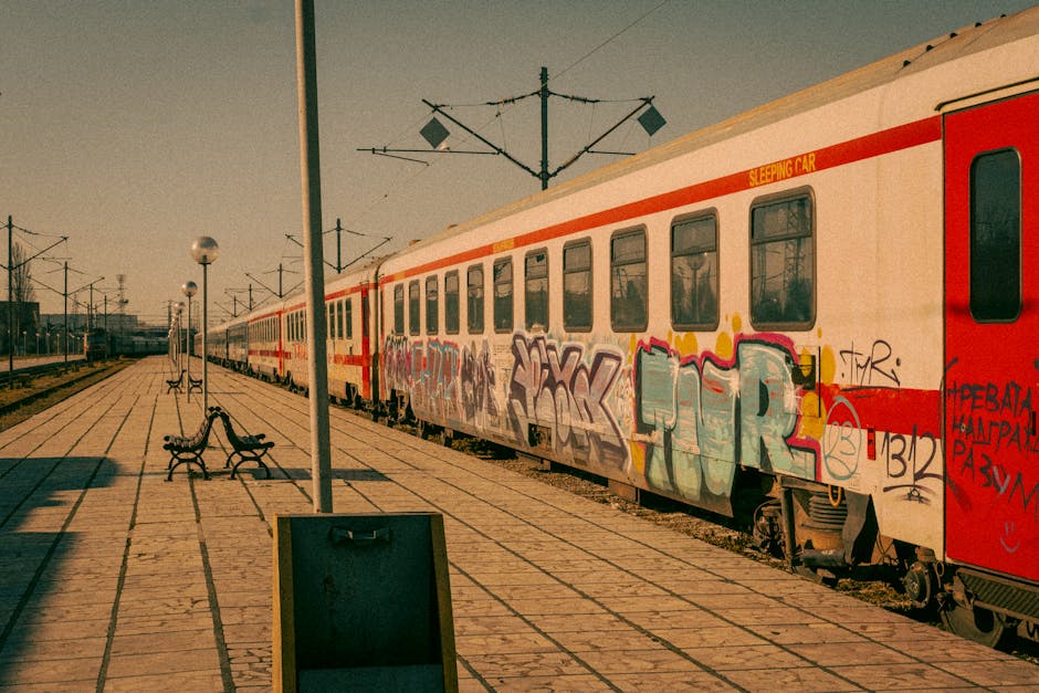 Graffiti-covered train at Varna station, Bulgaria, showcasing urban art in a vintage setting.