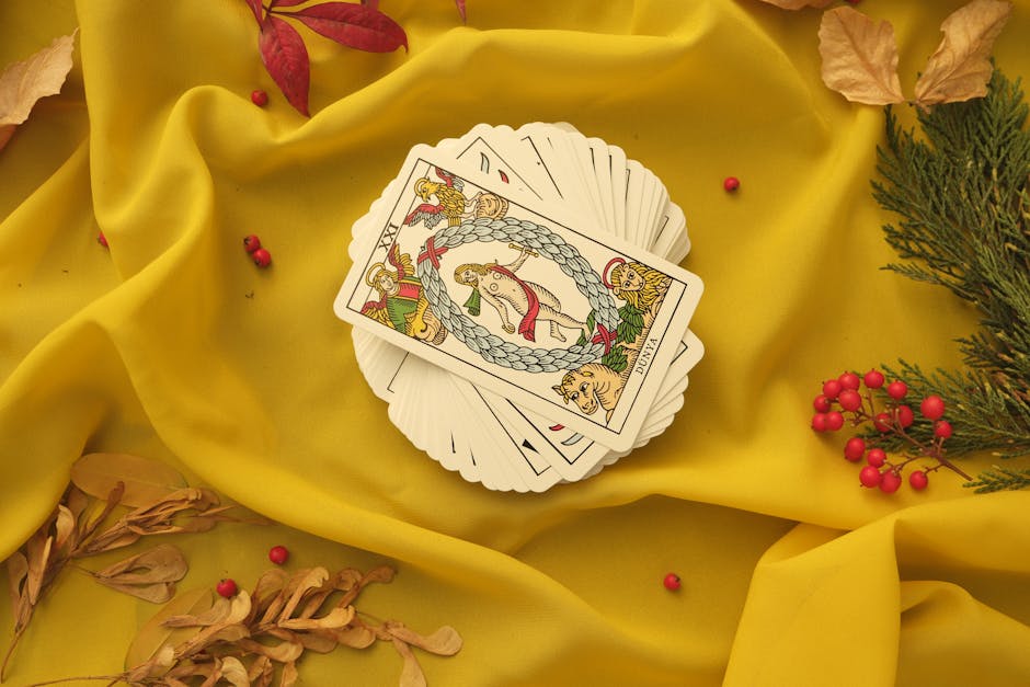 An artistic display of tarot cards on vibrant yellow fabric with decorative elements.